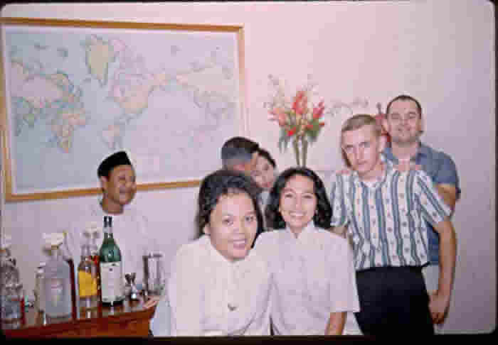 Local Scene - in my home, bartender Sieman (house boy) and Embassy personnel and members of Pangemanan family.